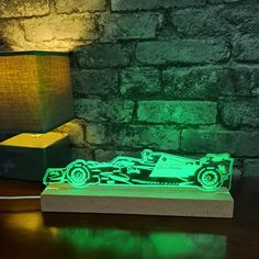 a green laser light on top of a wooden table next to a lamp and a brick wall