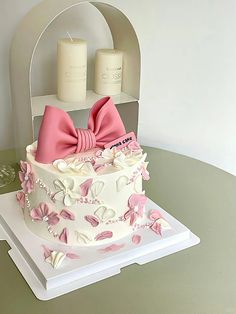 a white cake with pink bows and candles