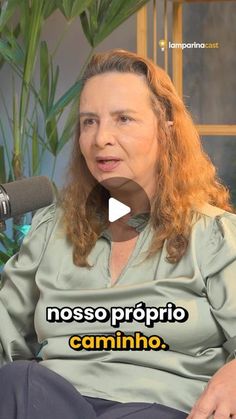 a woman sitting in front of a microphone with the words nosso proprio camino