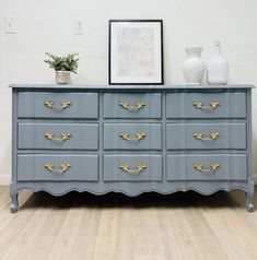 a gray dresser with gold handles and drawers