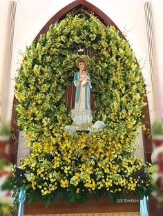 the statue is surrounded by yellow flowers and greenery