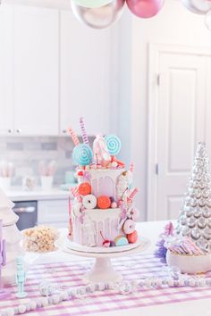 a birthday cake sitting on top of a table next to balloons and candy bars in the shape of trees