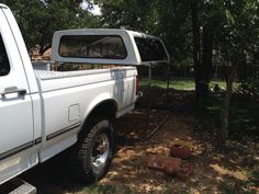 a white truck parked next to a tree