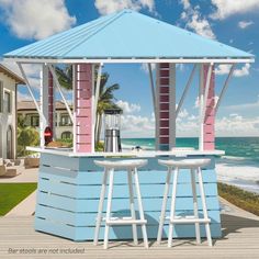 an outdoor bar with two stools next to the ocean