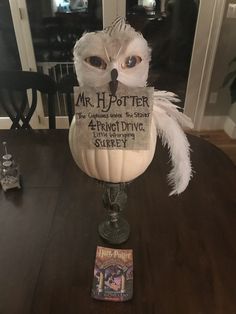 an owl sitting on top of a table next to a sign that says mr harry potter