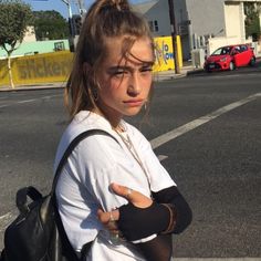 a young woman with her arm wrapped around her shoulder standing in the middle of an empty parking lot