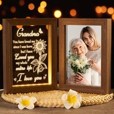 an old woman holding flowers next to a wooden frame with the words grandma and i love you