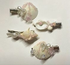 three hair clips with seashells and pearls on them are sitting next to each other