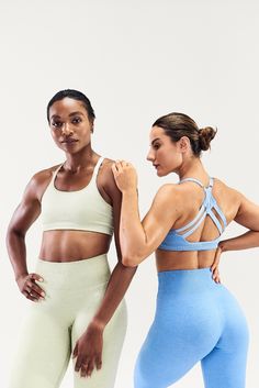 two women standing next to each other in sports bra tops and leggings with their hands on their hips