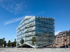 a large glass building sitting on the side of a road