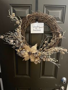 a wreath is hanging on the front door with dry grass and flowers in it,