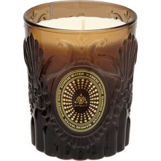 a glass candle with an ornate design on the front and side, in brown color