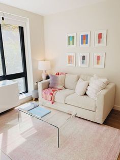 a living room filled with furniture and a glass coffee table on top of a hard wood floor