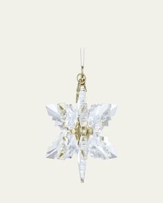 an ornament shaped like a snowflake hanging from a chain on a white background