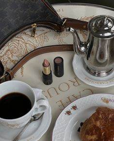 there is a cup of coffee and some pastries on the tray next to it