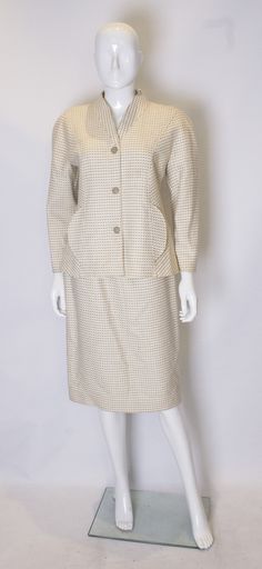 About A chic vintage wool skirt suit by Courreges. The jacket is wonderfully tailored, and has a three button central opening and two pockets at the front. The fabric has an ivory background with olive colour detail. The skirt fits smoothly over the hips, and has a central back zip. Measurements: jacket bust 37'', length 24'' skirt waist 29'', length 27'' Details Designer Courrèges Brand Courrèges Place of origin France Period 1980-1989 Material notes Wool Condition Good Dimensions D 27 in. D 68 Cream Long Sleeve Skirt Suit For Formal Occasions, Cream Skirt Suit For Spring Workwear, Cream Long Sleeve Skirt Suit For Work, Classic Beige Skirt Suit For Spring, Vintage Cream Blazer For Workwear, Vintage Cream Blazer For Work, Classic Tailored Beige Skirt Suit, Vintage Wool Skirt, Olive Colour