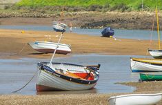 several small boats are docked on the shore