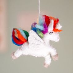 an ornament made to look like a white unicorn with multicolored hair