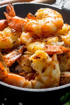 a skillet filled with cooked shrimp and garnished with parsley