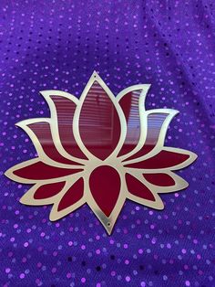 a red and white flower sitting on top of a purple cloth covered in polka dots