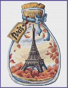 the eiffel tower in a glass jar with autumn leaves on it and a tag that says paris