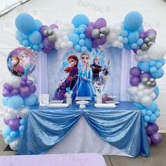 the balloon arch is decorated with blue and white balloons, which have frozen princesses on them