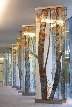 an office lobby with glass walls and trees painted on the wall