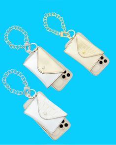 three white purses with chains hanging from them on a blue background, one has a chain around it