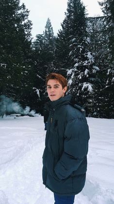 a man standing in the snow wearing a jacket