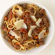 a white bowl filled with pasta and meat