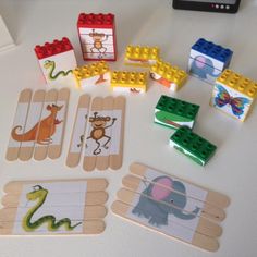 several wooden pegs with pictures of animals and dinosaurs on them, along with lego blocks