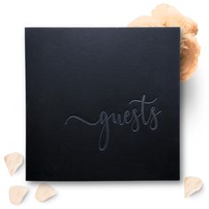 a black greeting card with the word guests written in cursive writing on it