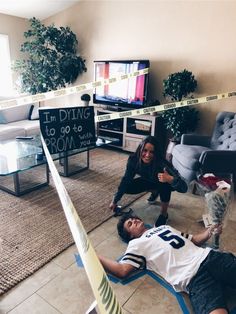 a man laying on the ground next to a woman in a living room with police tape