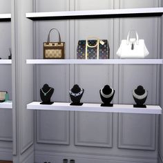 a display case filled with lots of different types of necklaces and purses on white shelves