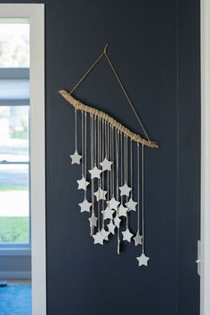 a wind chime hanging from the side of a wall with white stars on it