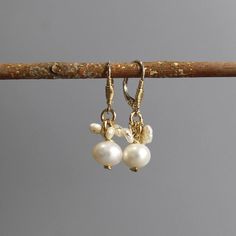 These wire wrapped earrings feature a beautiful pearl drop with incredibly unique wire wrapped details. Pearls are interwoven at the sides, making these small beauties elegantly delicate.  The hook is made of sterling silver and closes with a lever back. These handcrafted earrings will light up your everyday look. Perfect as a gift giving for your special someone or as a bridesmaid gift! Measurements: Earring's total length: approx. 3.5 cm including the hook Materials:  Stone: pearl Metal: gold filled, sterling silver  TURNAROUND TIME & SHIPPING  This piece will be made within 7 business days from the time of payment (excluding Fridays and Saturdays) and will be sent via registered air mail. Standard shipping takes approx. 10 business days to the US, and up to 21 business days to most dest Gold-tone Pearl Drop Dangle Earrings, Gold-tone Metal Pearl Drop Earrings, Gold Wire-wrapped Pearl Earrings, Shell-shaped Pearl Drop Earrings For Gifts, Dainty Pearl Earrings, Wedding Earrings Pearl, Adjustable 14k Gold-filled Pearl Drop Earrings, Pearl Cluster Earrings, Pearl Earrings Wedding