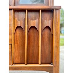 a wooden cabinet with four compartments and three doors