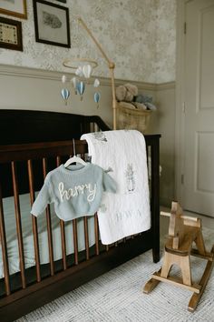 a baby's room with a crib, rocking chair and pictures on the wall