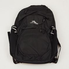 a black backpack sitting on top of a white floor