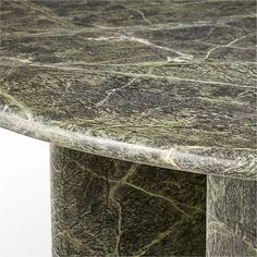 a green marble table with silver veining on the top and bottom, against a white background