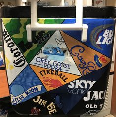 the back of a cooler covered in stickers and magnets, with various logos on it