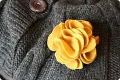 a gray sweater with a yellow flower on it