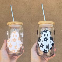 two hand painted mason jars with straws in them, one has a white and black bird on it