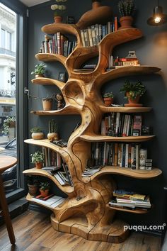 a wooden book shelf with books on it in front of a window and some potted plants