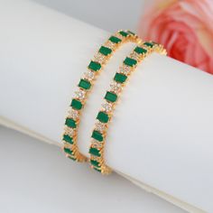 High quality beautiful pair of bangles intermittently studded with emerald cut emerald stones and and star design with CZ diamond crystals. 22k micro gold plated and high finish bangles available at indian Design in an affordable price. Diamond Bangles With Emeralds, Fine Jewelry Green Bangle For Anniversary, Green Diamond Bangle For Gift, Green Diamond Bangle As Gift, Green Fine Jewelry Bangle For Anniversary, Green Diamond Bangle As A Gift, Green Cubic Zirconia Bangle For Formal Occasions, Green Cubic Zirconia Bangle Jewelry, Green Cubic Zirconia Bangle