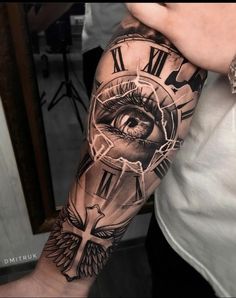 a man's arm with an all seeing eye tattoo on it and the clock behind him