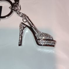 a close up of a shoe shaped keychain on a white surface with diamonds