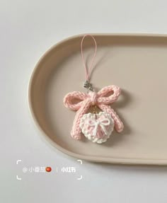 a pink crocheted ornament hanging from a tray