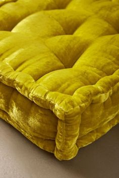 a close up of a yellow mattress on a white surface with no one around it