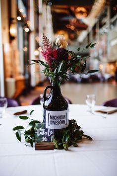 a vase with flowers sitting on top of a table next to a sign that says michigan awesome